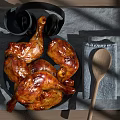 Juicy Roasted Chicken Legs On Plate With Gray Placemat Wooden Spoon And Cup On Table