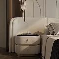 Modern Cream Colored Bedside Table with Drawers Books and Cup Next to Bed with Pillows