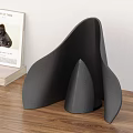 Modern Black Table Lamp with Curved Leaf Shade and Cone Base Emitting Warm Glow