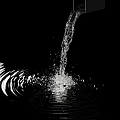 Garden Water Feature With Flowing Water Creating Ripples And Splashes Against Black Background