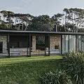 Rustic Guesthouse Architecture With Stone Wall Glass Facade Chimney And Trees In Green Grass Surroundings