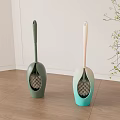 Modern Toilet Brushes With Green And Teal Handles On Wooden Floor Near Plant