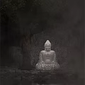 Buddha Sculpture in Sitting Posture with Stone Cave Background and Tree Elements