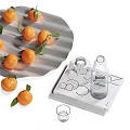 Fresh Tangerines with Green Leaves on Tray and Glassware beside Design Books