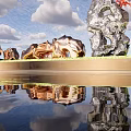 Golden and Silver Metal Sculptures By Water Reflection With Red Leaf Tree Under Blue Sky