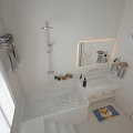 Bright Modern Bathroom Interior With White Bathtub Backlit Mirror Vanity Sink And Rug