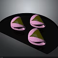 Three Pink Shell Green Filling Snacks on Black Fan Shaped Plate