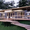 Wooden Guesthouse Building With Terrace Lawn And Surrounded By Trees