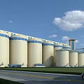 Industrial Plant Featuring Large Silos Green Lawn And Blue Sky With White Clouds