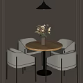Round Wooden Table And Gray Chairs With Vase Of Flowers And Hanging Black Pendant Light