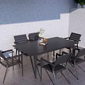 Black Outdoor Table with 6 Chairs Set in Gray Wall Patio Area