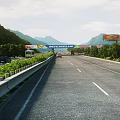 Highway Road Facilities Featuring Multiple Lanes Green Belts Trees Billboards And Scenic Mountain Views