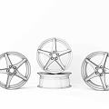 Three Stylish Wheel Rims with Silver Black Chrome Finishes Modern Spoke Design on Dark Countertop