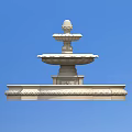 White Multi Tiered Water Fountain With Decorative Base Against Blue Sky