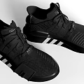 Pair Of Black Sports Shoes With White Stripes And Modern Design