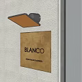 Modern Wall Light Mounted on Concrete Wall Illuminating Gold BLANCO Sign