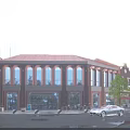 Commercial Street Red Brick Buildings Arched Windows Illuminated Evening Atmosphere Pedestrians Parked Cars and Trees