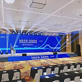 Professional Conference Hall Setup With Blue Backdrop Stage Podium And Seating Arrangement