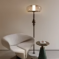 Modern Floor Lamp With Brass Base And Glass Shade Beside Cozy Chair And Side Table