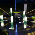 Illuminated Art Installation With Circular Pool Green Pillars And Laser Beams At Night