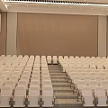 School Building Auditorium Interior With Rows Of White Seats And Large Projection Screen