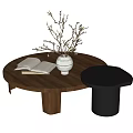 Round Wooden Coffee Table With Open Book White Vase Twigs And Black Side Table