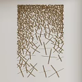 Intricate Wall Decor With Crossed Golden Slender Strips On White Wall