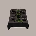 Elegant Tableware Set with Black Plates Wine Glasses Candles and Green Foliage