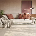 Beige Multi Seater Sofa With Brown Cushions Plaid Blanket Wall Art And Floor Lamp