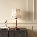 Elegant Table Lamp With Floral Shade Wooden Base On Dark Cabinet And White Bust Sculpture