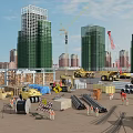 Busy Construction Site With High Rise Buildings Cranes Heavy Machinery Materials And Workers