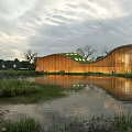 Modern Commercial Complex With Curved Wooden Exterior By Waterfront And Reflection