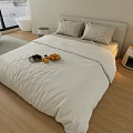 Modern Double Bed with White Bedding Wooden Floor Nightstand Lamp and Fruit Plate