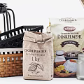 Baking Essentials Cocoa Powder Flour in Paper Bags Wicker Baskets and Glass Jar