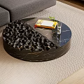 Modern Round Black Coffee Table with Textured Surface Holding Notebook Pen Glass and Small Plant