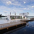 Waterfront Container Building With Staircase Wooden Platform And Small Boat On Lake