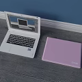White Dell Laptop Open With Screen Display And Pink Laptop Case On Wooden Floor