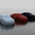 Three Covered Cars In Light Blue Red Dark Blue On Smooth Black Surface