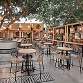 Outdoor Restaurant With Trees Wooden Structure Hanging Lights And Patterned Floor