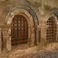 Cartoon Scene of Ancient Stone Arches with Carved Pillars and Wooden Doors in Medieval Courtyard