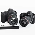 Two Canon Digital Cameras Placed On Photography Book For Gear