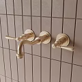 Golden Faucet Mounted On Grey Tile Wall With Two Handles