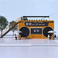 Yellow Radio Shaped Container Building With Staircase Trees And Seated People Under White Umbrellas