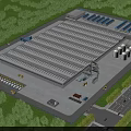 Industrial Factory Building Featuring Spacious Roofing Surrounding Greenery and Truck Parking Areas