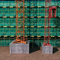 Swing Door Installation On Construction Site With Scaffolding And Tower Cranes