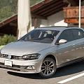 Silver Volkswagen Hatchback Parked Outdoor Near Scenic Buildings And Greenery View