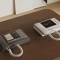 Gray And White Telephones With Display Screens And Curly Cords On Wooden Table