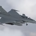 Modern Gray Fighter Jet Flying in Cloudy Sky with Landing Gear and Armaments