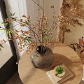 Decorative Vase With Dried Branches And Small Flowers On Round Wooden Table With Traditional Mural