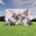 Outdoor Floral Installation With Purple White Flowers Green Grass And Blue Sky Backdrop